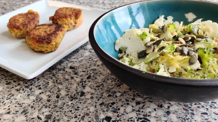 Quinoafrikadeller med gulerod serveret med kålsalat i turkis skål.