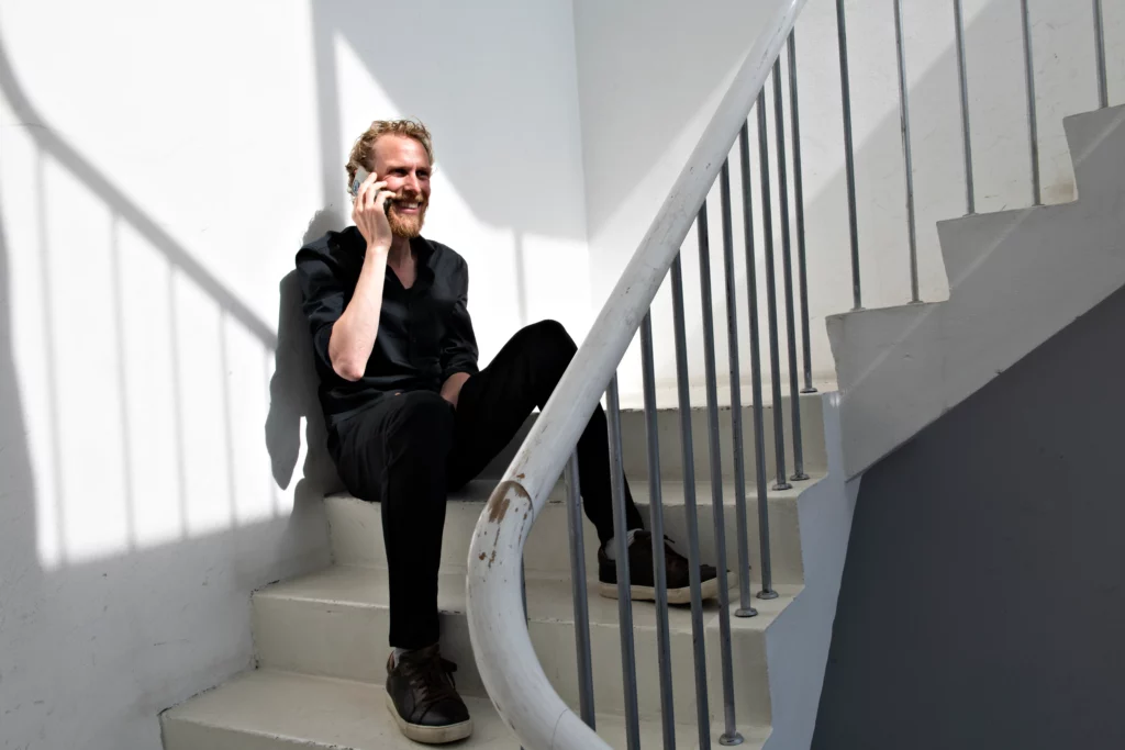 En person snakker i telefon på en trappe