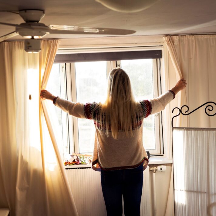 Nina Vase trækker gardinet fra i sit hjem.