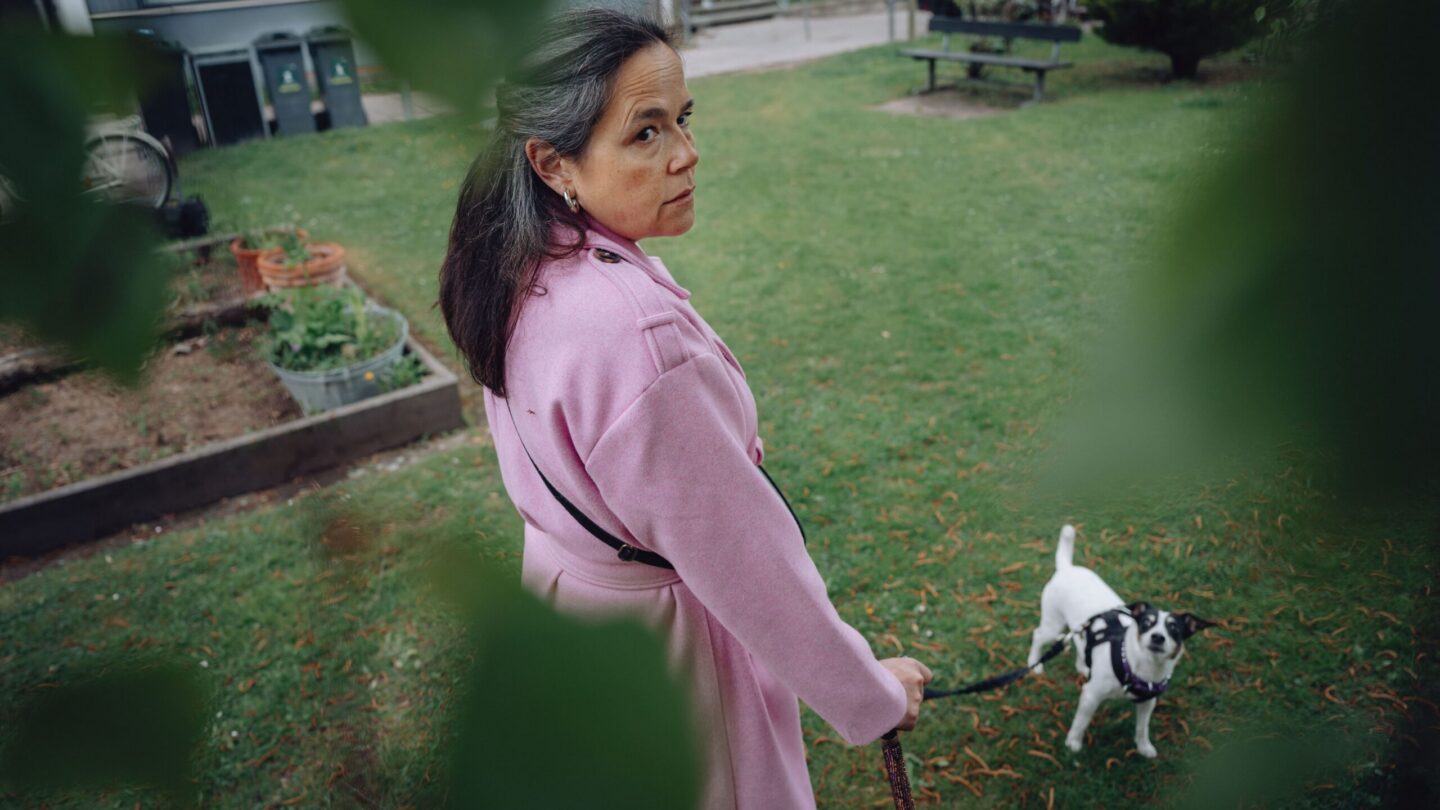 Helene Kreutzman går tur med sin hund i grønne omgivelser