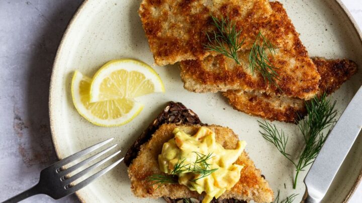 Smørrebrød med paneret selleri a la fiskefilet serveret på stentøjstallerken.