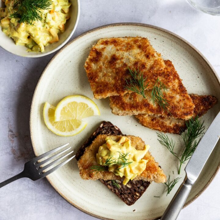 Smørrebrød med paneret selleri a la fiskefilet serveret på stentøjstallerken.