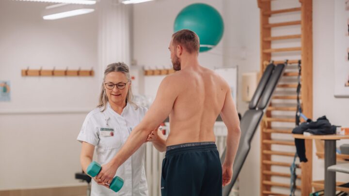 Birgitte Hougs Kjær viser, hvordan en skulderpatient skal lave øvelserne.