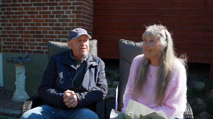 Iben og Claus sidder i havestole - Iben holder en stor blomsterbuket