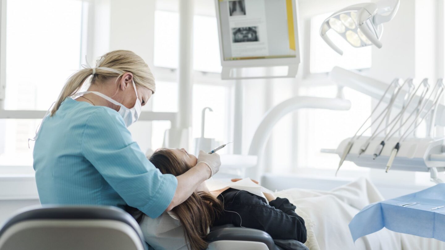 Tandlægebehandling - tandlæge og patient i tandlægestol