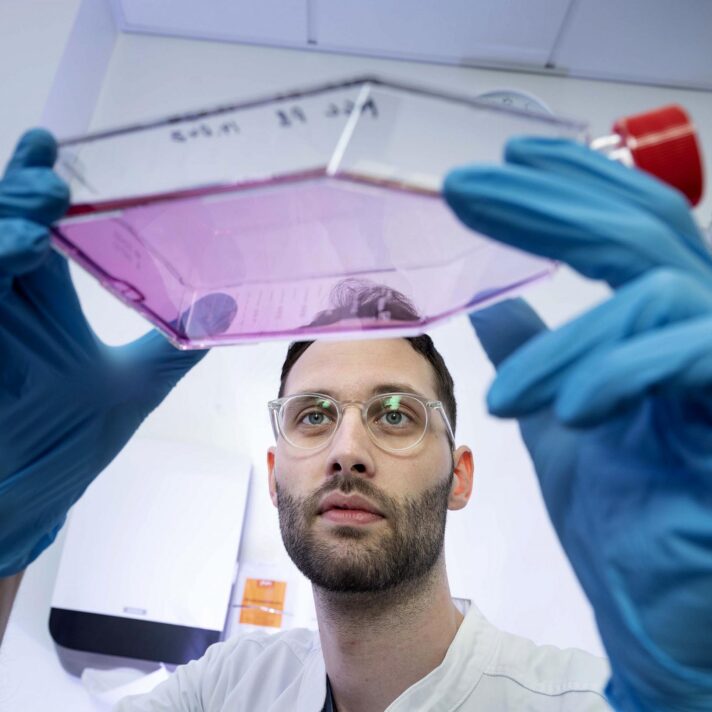 Gigtforsker Rasmus Roost Aabling i laboratoriet. hvor han holder beholder op med væske.