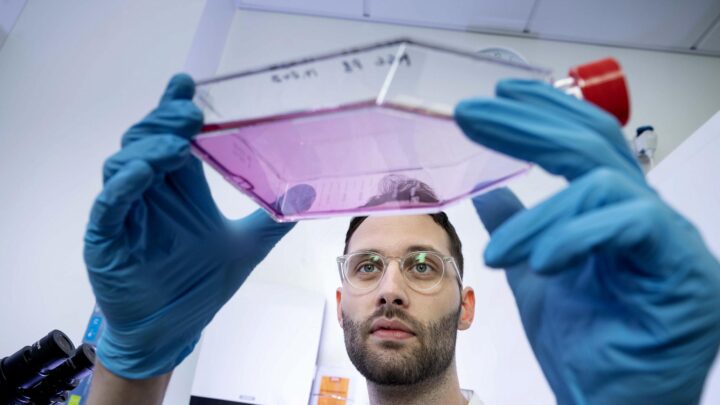 Gigtforsker Rasmus Roost Aabling i laboratoriet. hvor han holder beholder op med væske.