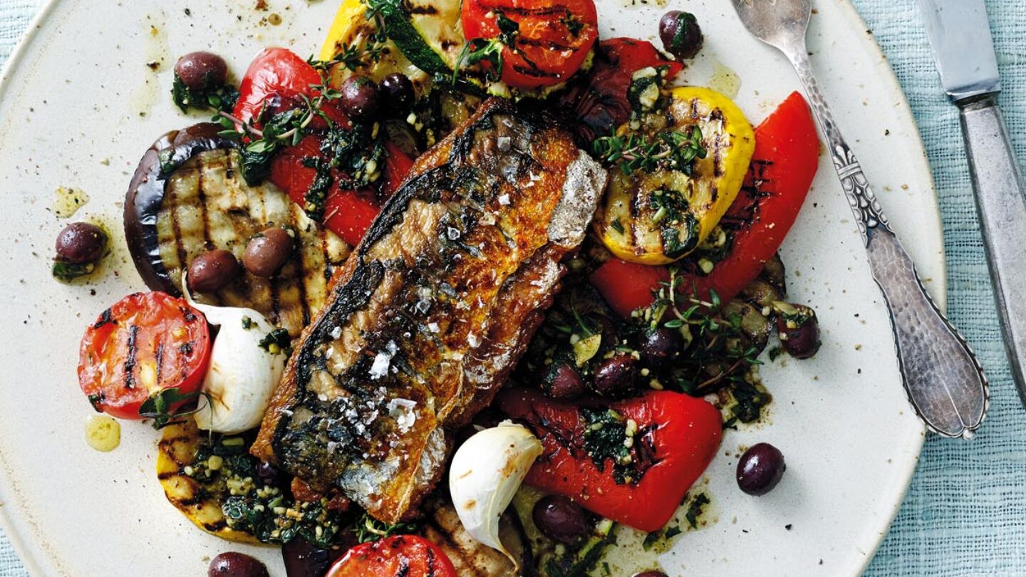 Skindstegt makrel med provencalske grøntsager serveret på en hvid tallerken på lyseblå dug