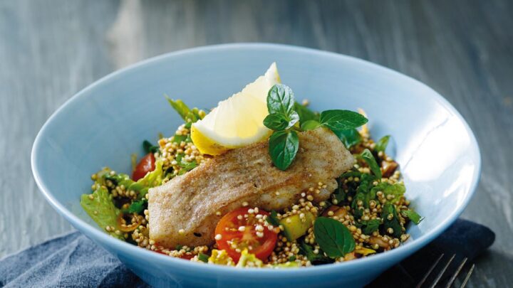 Stegt mørksej med quinoa tabbouleh serveret i en lyseblå dyb tallerken.