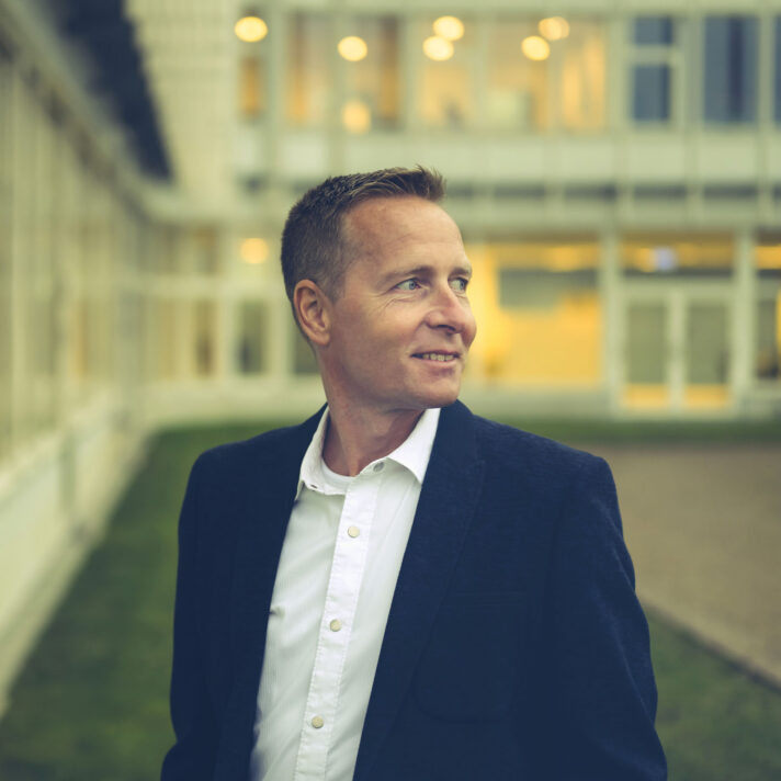 Smerteforsker Morten Høgh fotograferet foran en lys bygning.